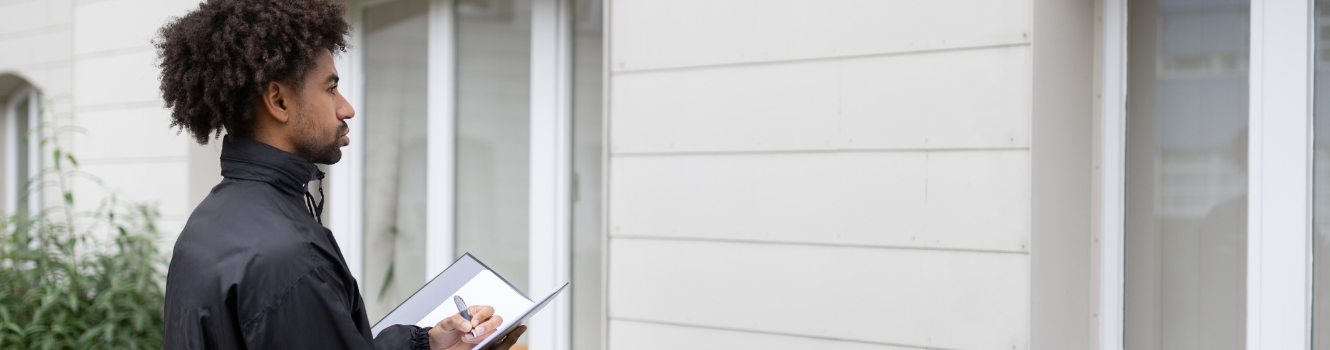 Man with clipboard visiting homes