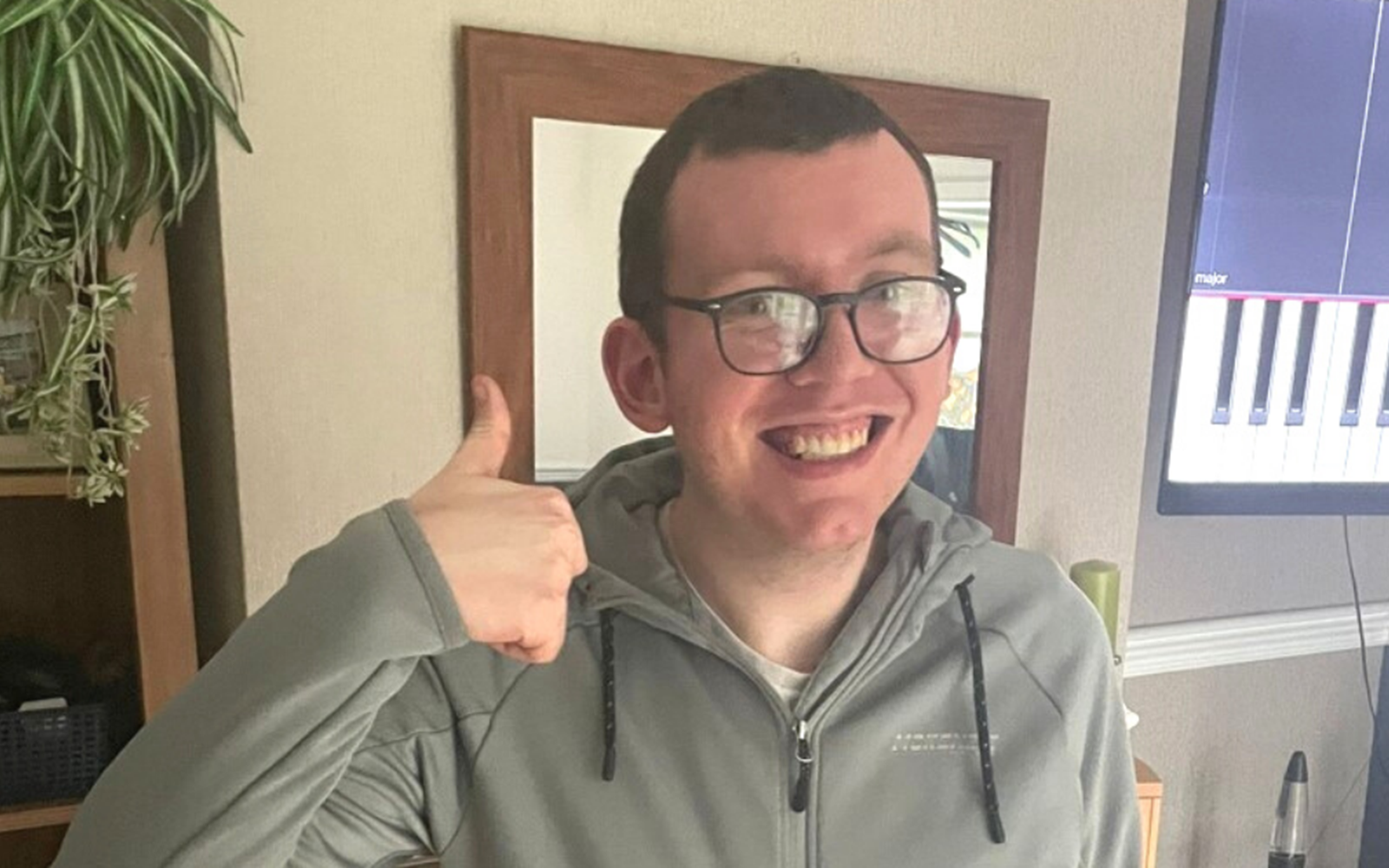 Ben smiling for the camera with a thumbs up