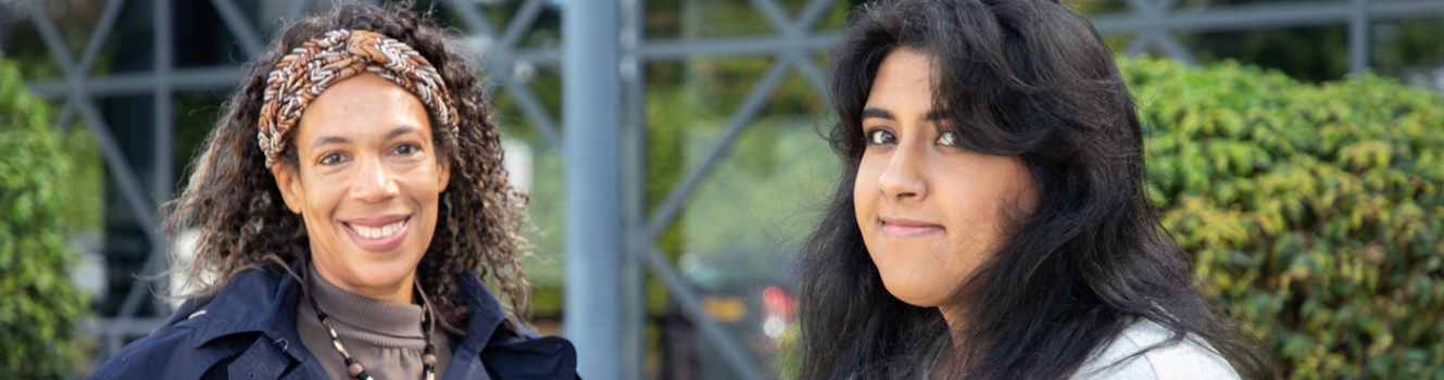 Two ladies smiling at the camera outside