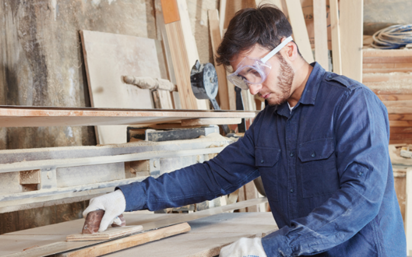 Callum handling woodwork, with goggles on.